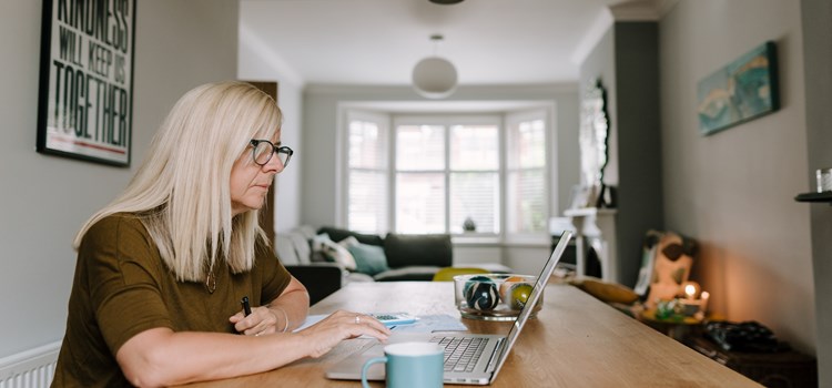 New tool to support careers in social care under development image A woman looking at a laptop at home image