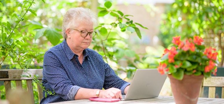 Repurposing Turas Learn educational resources for social care image Person sat at a garden table using a laptop image