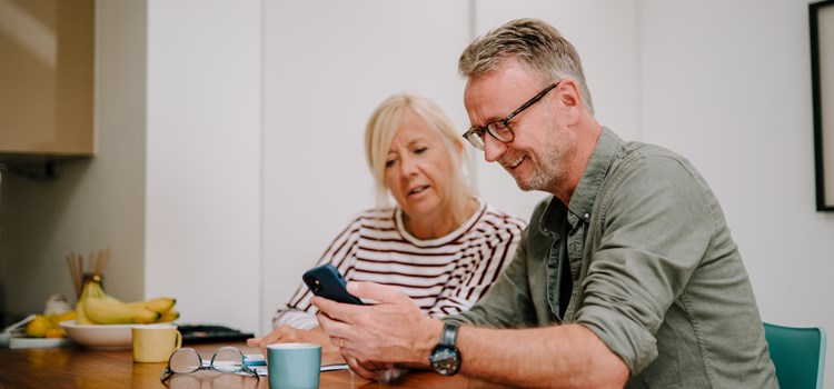 Social care mailing list image Two people sat at a table looking at a mobile phone image